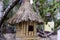 Image of a bird house. A bird house made of bamboo under a thatched roof.