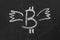 Image bitcoin with wings chalk on a chalkboard.