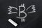 Image bitcoin with wings chalk on a chalkboard.