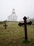 Image of black iron crosses standing at the cemetery on the background of the Norwegian Church