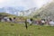 Image of a black umbrella stuck on ground with view of highland mountains and village