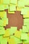 Image of blank green and yellow sticky notes on cork bulletin bo