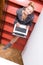 Image of blond young pretty business or female student having fun working typing on laptop computer relaxing sitting on stairs