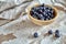 Image of blueberries in wooden bowl on rustic village table