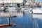 Image of a bow of a sailboat in the harbor with sailboats moored in the background