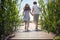 Image of boy and girl holding hands, running barefoot on wooden platform  toward the water