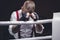 Image of a brutal man standing near the ropes of the ring. He prays before the fight. The concept of fist fights