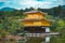 Image of a building with a Japanese architectural exterior on the water surrounded with nature.