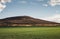 Image - Castle on the hill with field and blue cloudy sky on sunset. Sun rays shining through clouds on meadow and ruins on the