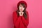Image of caucasian darkhaired modest woman wearing red beret and sweater, model posing isolated over rosy background in studio,