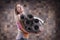 Image of a cheerful adult woman carrying a stack of rolled exercise mats. Yoga and pilates concept. Training, dancing and posing