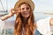 Image of cheerful ginger woman gesturing peace sign and taking selfie