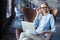 Image of cheerful office woman with blond hair in business wear sitting on chair and working with laptop office.