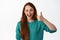 Image of cheerful redhead student girl shows thumb up, winks and say yes, agree and support great idea, praise good job