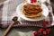 Image of cheese pancakes with sour cream and fresh berries, blackberry jam in wooden spoon, whipped cream on muffins top, served