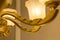 An image of a classic ceiling chandelier in switched-on state with a white frosted plafond on a gold armature