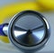 Image of close up with detail of yellow stethoscope on grey background