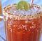 Image of close up of michelada drink in glass with sugar frosted edge and slice of lime