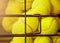 Image of Close up view of balls in basket on clay tennis court. Focus on balls