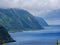 Image of cloudy and foggy coastline with green mountains full of trees and forest on the island of Sao Jorge, Azores, Portugal,