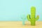 Image of colorful cactus decoration infront of wooden blue background.