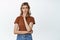 Image of concerned woman looking hesitant aside, thinking of something, standing against white background