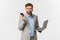 Image of confused businessman in grey suit and glasses, receive bad news during phone call, holding laptop and