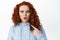 Image of confused and shocked redhead female model pointing at herself and look worried, being accused or blamed