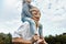 Image of cute little funny daughter on a piggy back ride with her happy mother. Loving woman and her little girl playing in the