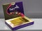 Image of dairy milk chocolate in commercial packaging isolated on grey background.