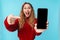 Image of delighted nice woman showing and pointing finger at cellphone