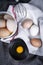 Image of egg yolk in a bowl next to healthy eggs in a dish or white  cloth and kitchen utensils.