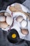 Image of egg yolk in a bowl next to healthy eggs in a dish or white  cloth and kitchen utensils.