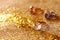 Image of elegant gold rings on gold glitter background