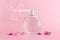 Image of elegant perfume bottle spraying over pink pastel background