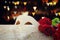 Image of elegant venetian mask and red roses over wooden table