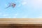 Image of empty rustic table in front of Colorful kite flying in the blue sky through the clouds. For product display presentation.