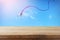 Image of empty rustic table in front of Colorful kite flying in the blue sky through the clouds. For product display presentation.