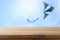 Image of empty rustic table in front of Colorful kite flying in the blue sky through the clouds. For product display presentation.