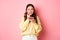 Image of excited girl thinking of eating delicious cake, biting finger from temptation and looking thoughtful at camera