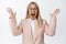 Image of excited saleswoman in suit reacting to awesome news, looking amazed and happy, standing over white background