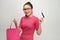 Image of excited screaming young woman standing holding shopping bags and credit card