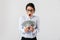 Image of excited secretary woman wearing eyeglasses holding bunch of money in the office, isolated over white background