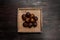 Image of exotic tropical salak fruit also known as snake fruit. View from the top of nine fruits in a straw plate on a brown