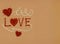 The image features red and white thread with the word love and red hearts. The background is light brown