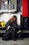Image of female firefighter with black dog sitting on background of fire truck