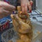 Image of female hands filling a raw and fresh whole chicken with ground meat already prepared