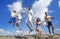 Image of five energetic people jumping at the beach