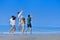 Image of five energetic people jumping at the beach