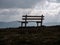 Image with focus of bench with mountains in the background